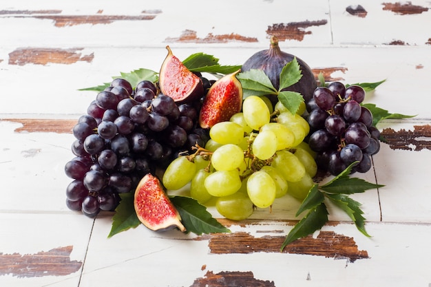 Still life of fresh autumn fruit. Grapes black and green