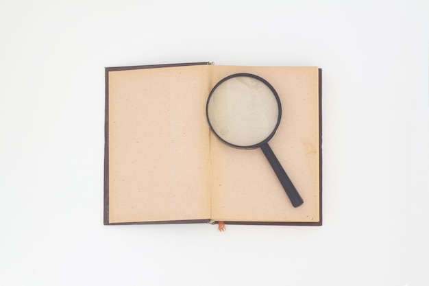 Still life from a magnifier and a pile of old books on a white background