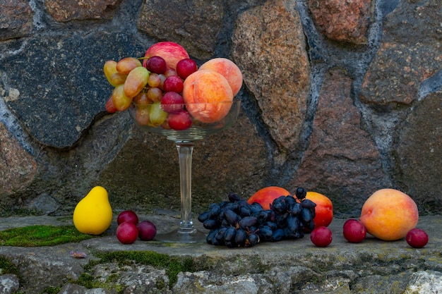 Still life of fruits rich harvest peaches and grapes