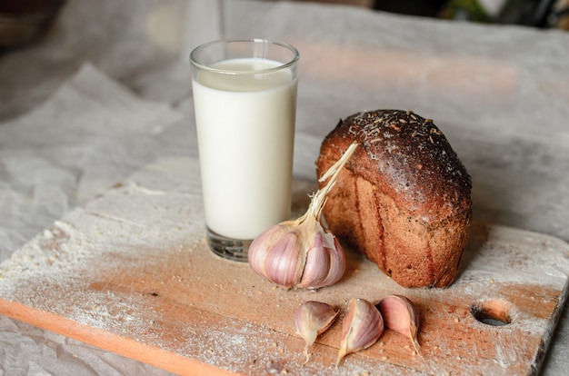 Still life di latte, pane e aglio.