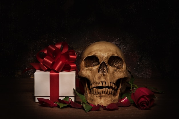 Still life painting photography with human skull, present, rose