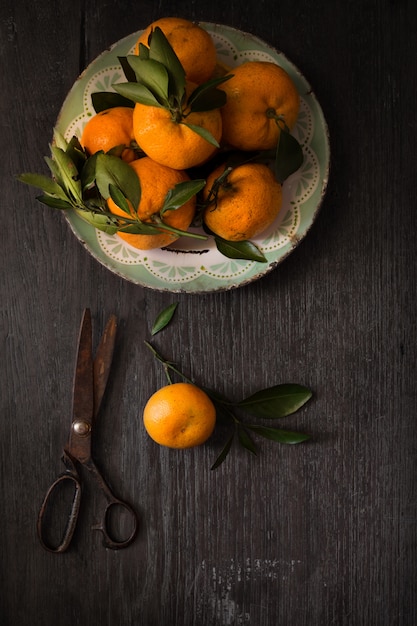 Still life photography. Dark moody food image of fresh ripe citrus on wooden table