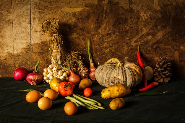 Fotografia di natura morta con zucca, spezie, erbe, verdure e frutta.