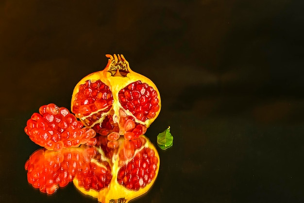 Still life of pomegranates on a black background and reflection
