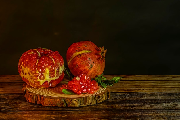 Still life of pomegranates on a wooden table and a black background