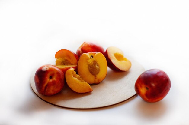 Still life of ripe nectarinesfull and cut in half on light window background