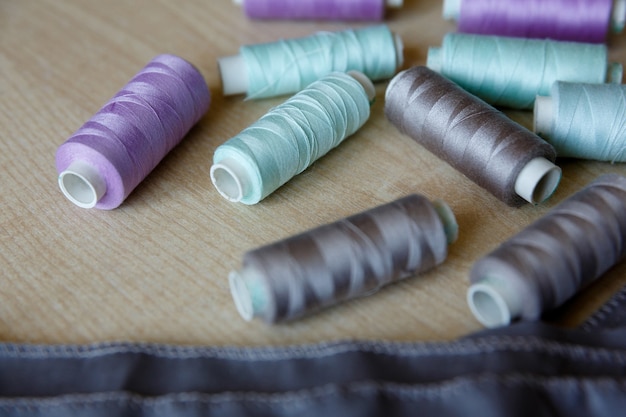 Still life. Sewing supplies. Threads and fabric lie on wooden table