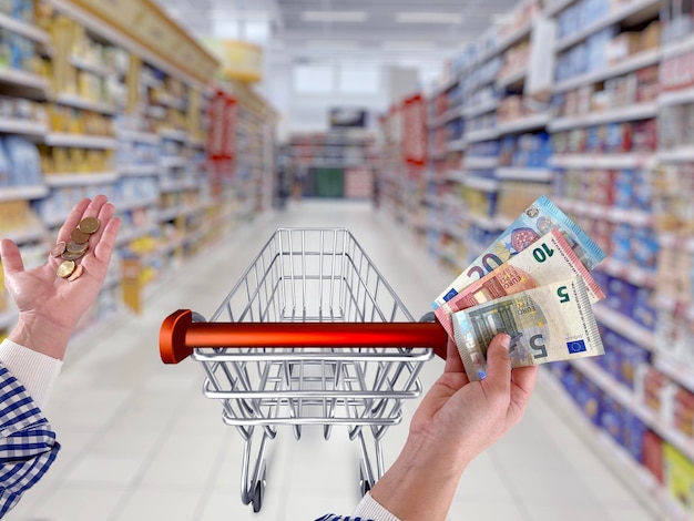 Still life of shopping cart and euro notes on supermarket background stock photo