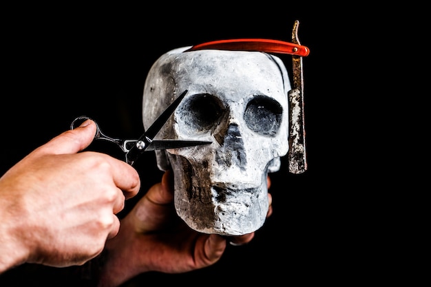 Still life skull with shaving tools. Barber shop tool on black background