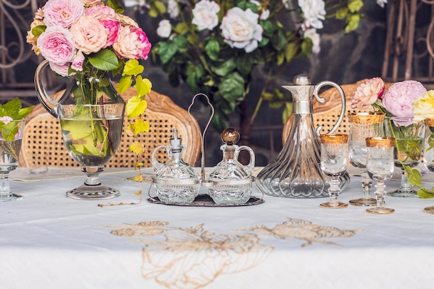 Foto natura morta, tavola apparecchiata per cena romantica, matrimonio, colori rosa, rose rosa, bicchieri di cristallo