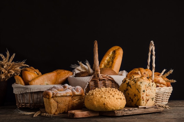 Still life of a varied assortment of breads on a black wall