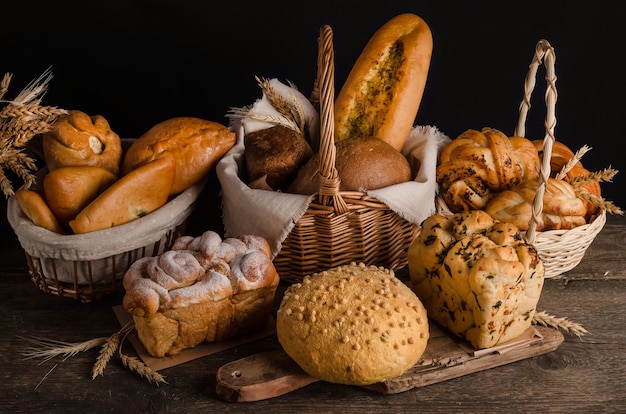 Still life of a varied assortment of breads on a black wall