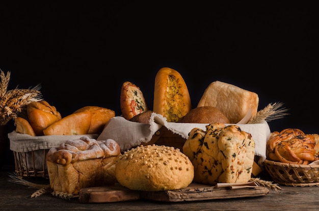 Still life of a varied assortment of breads on a black wall