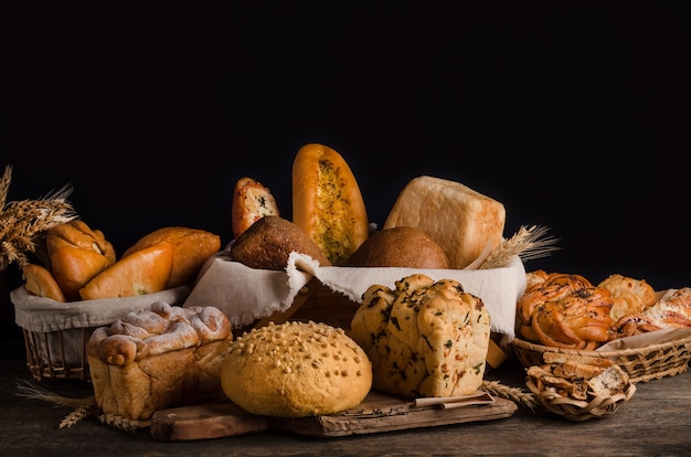 Photo still life of a varied assortment of breads on a black wall