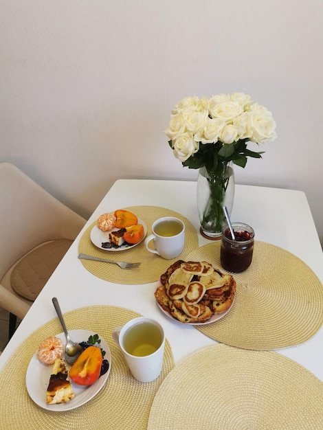 사진 장미 꽃다발 과 아침 식사 식품 과 함께 고정 된 생명 축제 테이블 설정