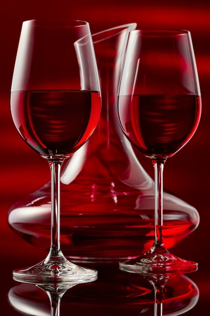 Фото Натюрморт с графином и двумя бокалами красного вина на блеске