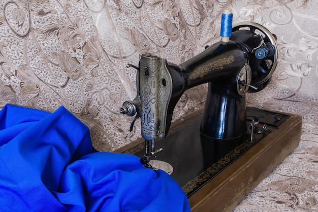 Still life with antique sewing machine and and bright blue fabric