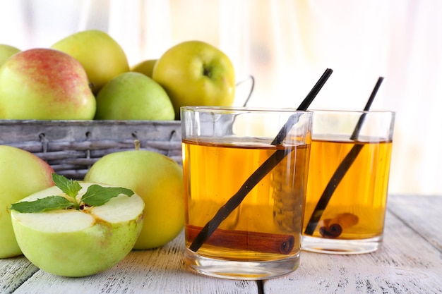 Still life with apple cider and fresh apples on wooden table