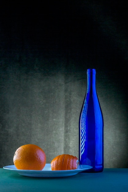 Still life with blue bottle and orange