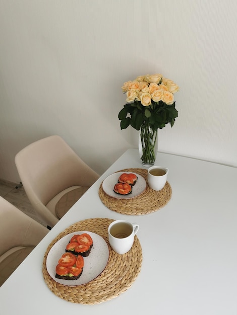 장미 부케와 아침 식사 음식이 있는 정물 축제 테이블 세팅
