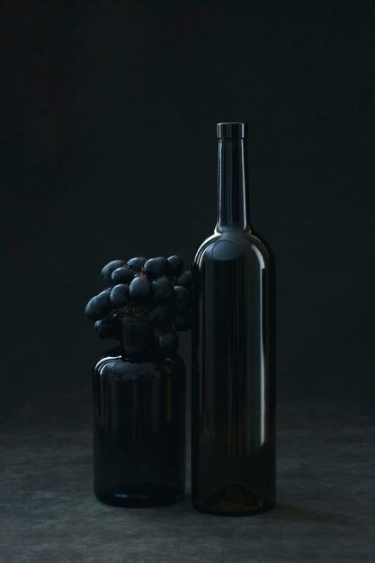 Photo still life with a bunch of grapes and glass bottles