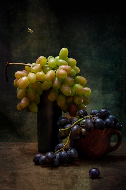 Still life with bunches of ripe grapes and a bee