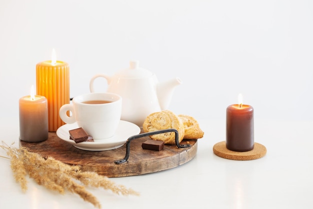 Still life with burning candles in white modern interior