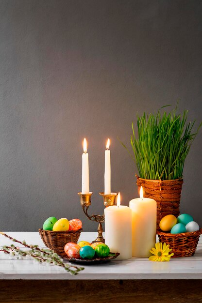 Foto natura morta con candele e uova di pasqua per pasqua