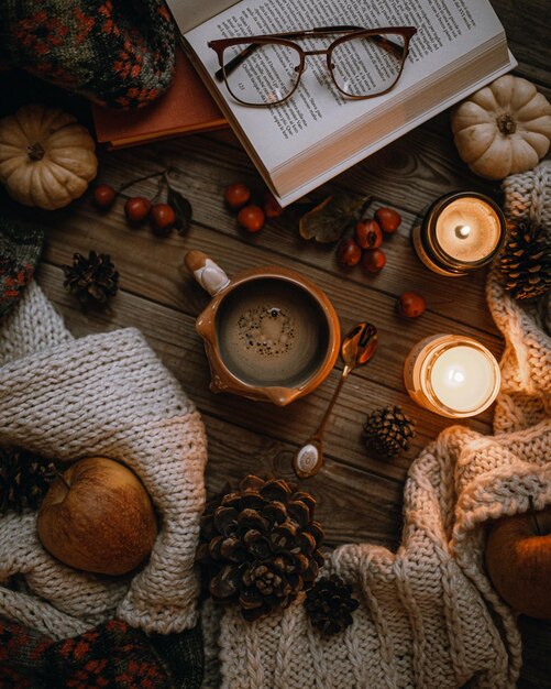 Foto natura morta con candele per tazze di caffè e conie di pino