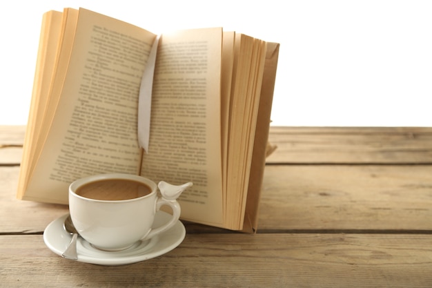 Натюрморт с чашкой кофе и книгой на деревянном столе,