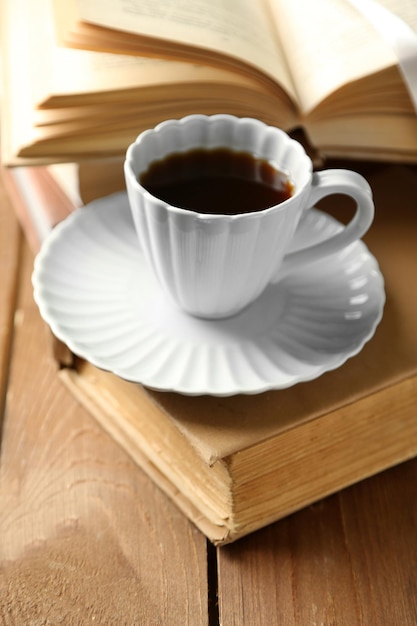 Still life with cup of coffee and books on wooden table