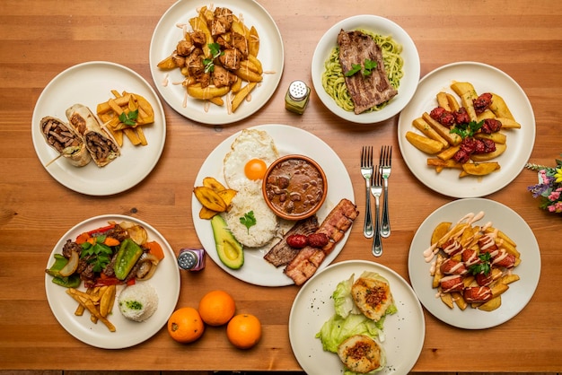 A still life with dishes of Peruvian and Ecuadorian gastronomy chorizo with fried potatoes a combined plate with rice and avocado lomo saltado fillet with green noodles stuffed potato