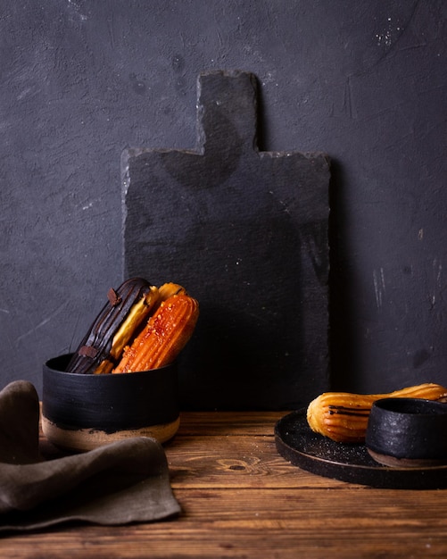 still life with eclairs on a dark background