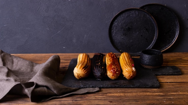 Photo still life with eclairs on a dark background