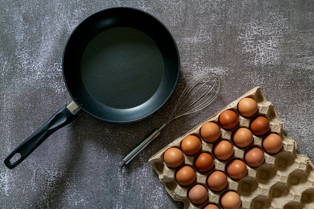 Натюрморт с яйцами и сковородой на деревянном столе