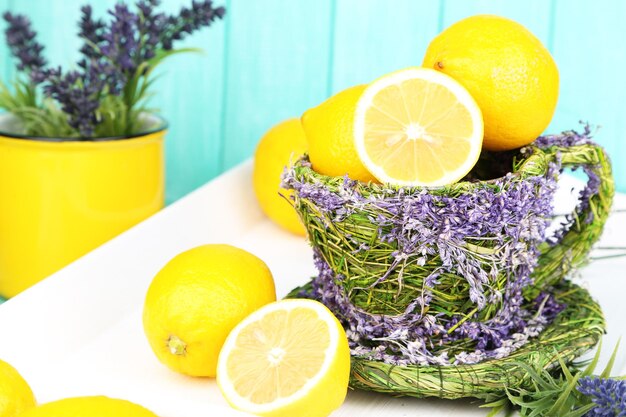 Still life with fresh lemons and lavender on blue background