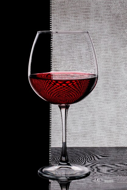 Still life with a glass of red wine on a dark background