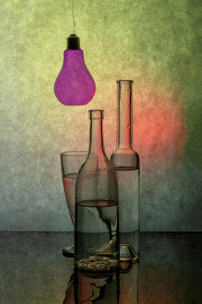 Still life with glassware with liquid and a light bulb