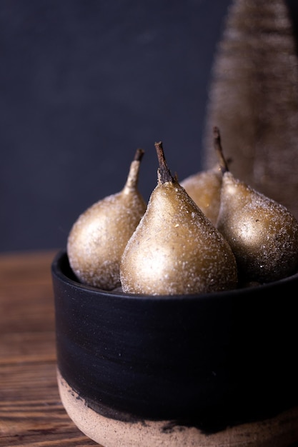 Photo still life with golden pears on a dark background