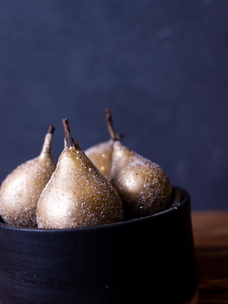 Photo still life with golden pears on a dark background