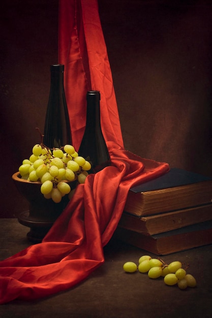 Still life with grapes old books and bottles