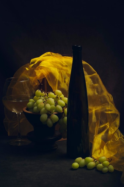 Still life with grapes wine and yellow cloth