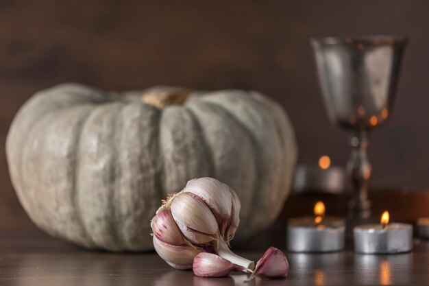 Still life with head of garlic pumpkin chalice and candles image of hallowen