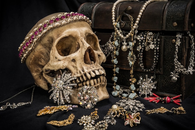 Still life with a human skull with old treasure chest and gold,\
diamond