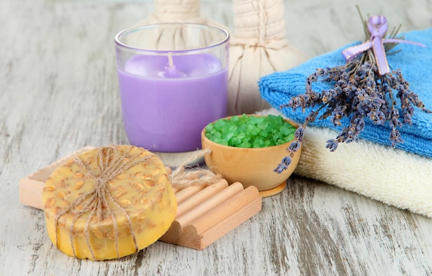 Still life with lavender candle soap massage balls bottles soap and fresh lavender on wooden background