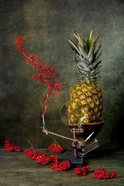 Still life with pineapple and red viburnum berries