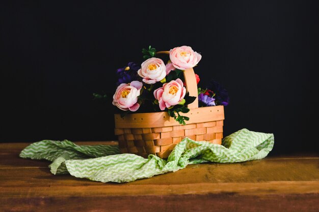 Still life with pink roses in basket on the table .