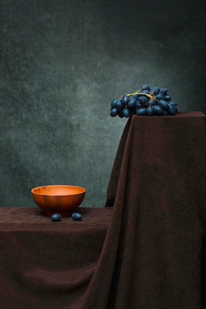 Still life with a plate and a bunch of ripe grapes