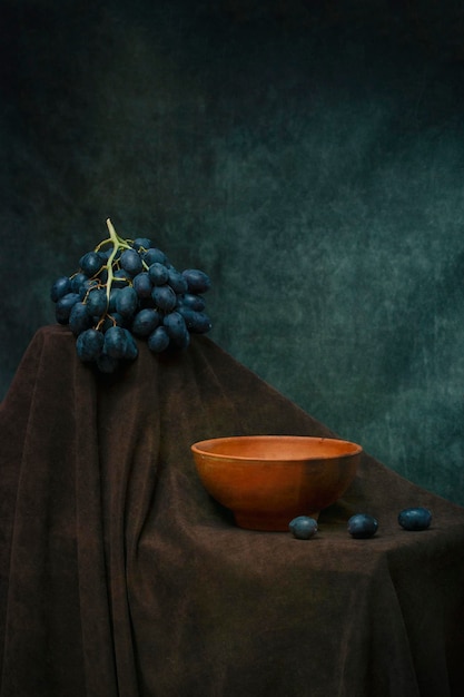 Foto natura morta con piatto e grappolo d'uva maturo
