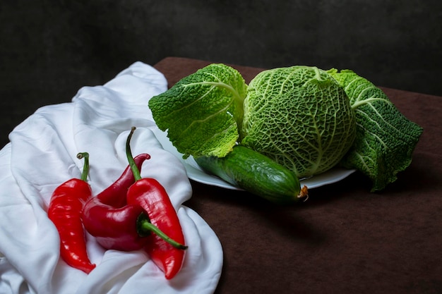 Still life with Savoy cabbage tomatoes cucumber and red pepper